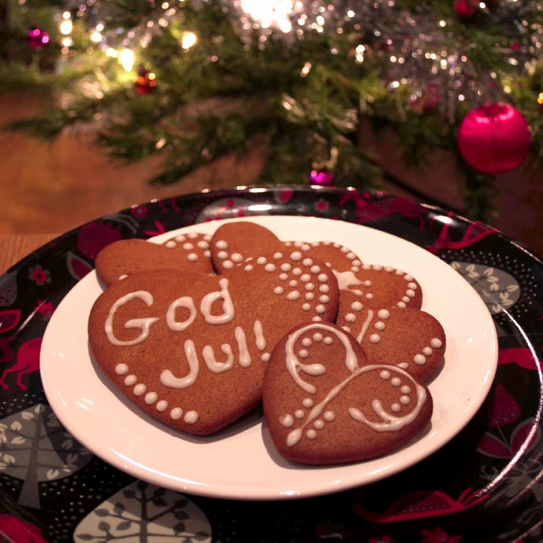 Hjärtformade pepparkakor på ett fat, varav en har texten 'God Jul'.