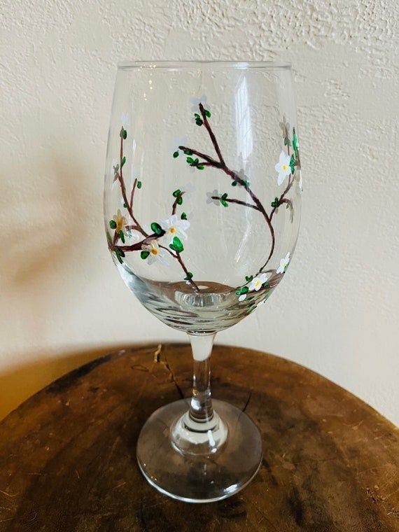 Dekorerat äldre vinglas i klart glas på ett träbord